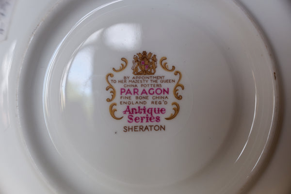 The underside of a white porcelain plate or dish showing a printed Royal Mint style mark for Paragon Antique Series Sheraton, with gold and pink lettering.