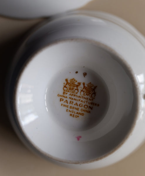 Close-up of the inside bottom of a white porcelain cup or teacup, showing a gold Paragon mark and text reading 'By Appointment China Manufacturer Paragon Fine Bone China England Reg.'.