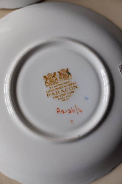 The underside of a white porcelain plate or saucer showing a gold-foiled Papacon mark with the British coat of arms, alongside a red handwritten serial number.