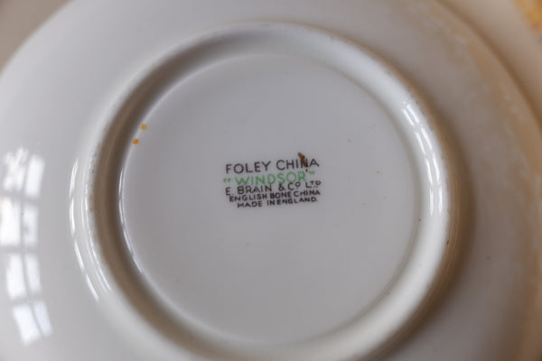 The bottom of a white ceramic plate or dish with a printed maker's mark reading 'FOLEY CHINA WINDSOR E. BROWN & CO LTD ENGLAND 1937 CHINA MADE IN ENGLAND'.