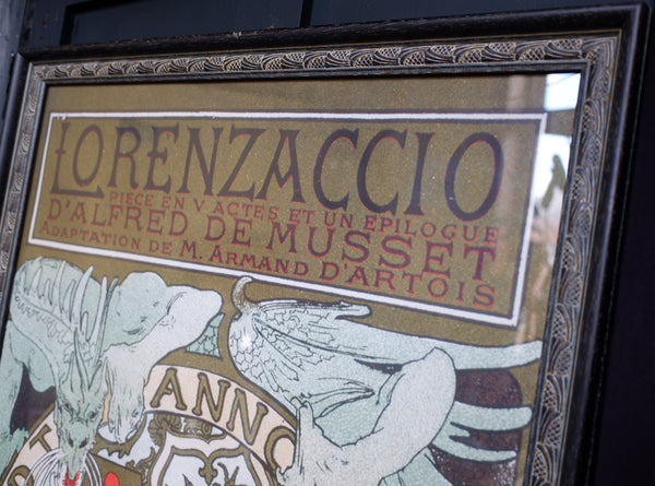 A framed vintage-style poster or print with French text reading 'LORENZACCI0' and illustrated wings, shown close up against a dark background.