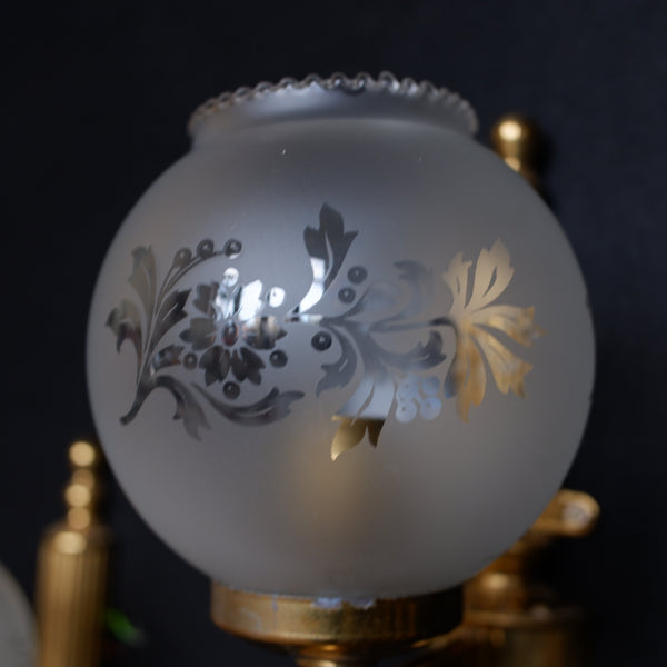 Decorative glass lampshade with floral etching on a dark background